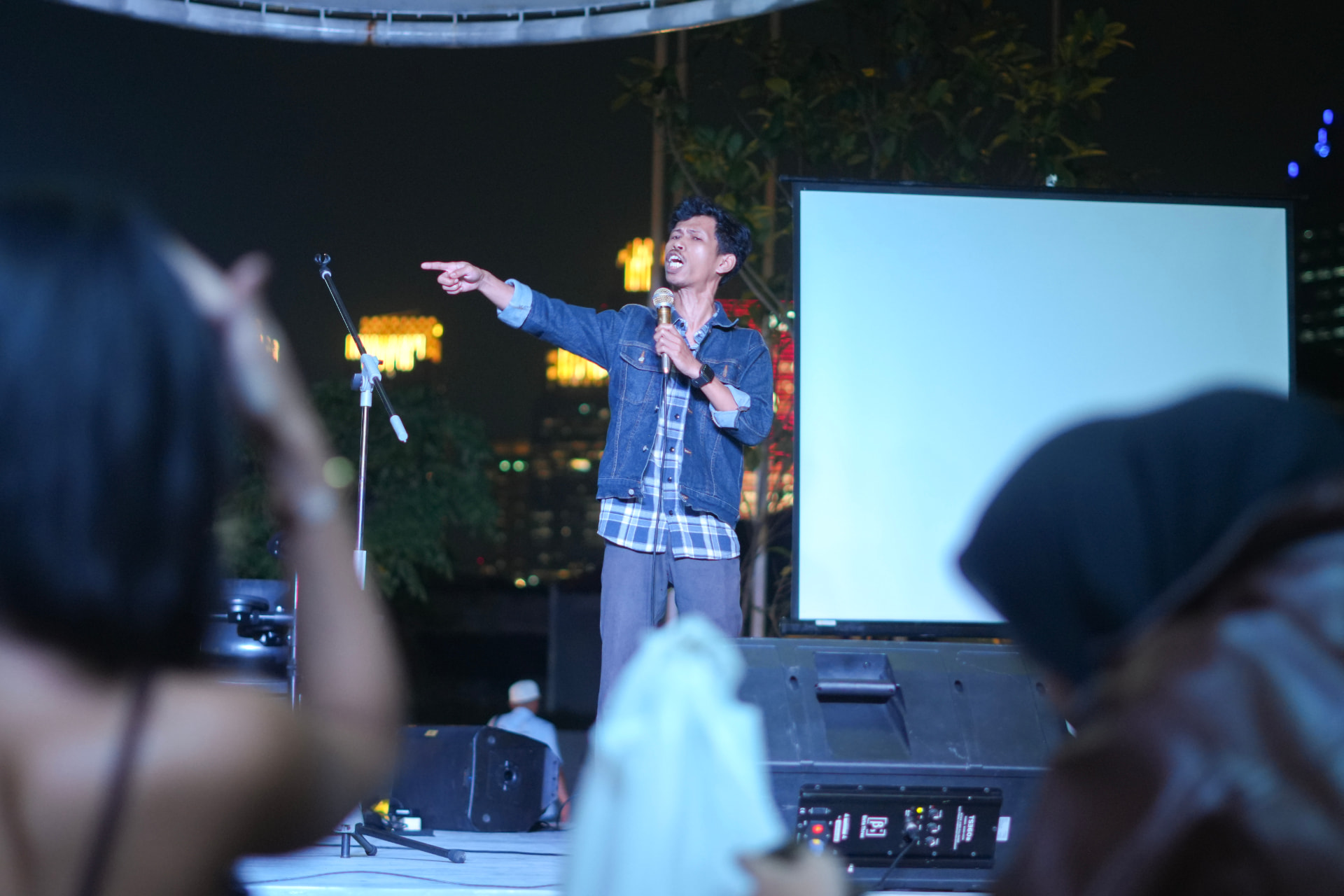 Comedian pointing at the crowd mid-punchline
